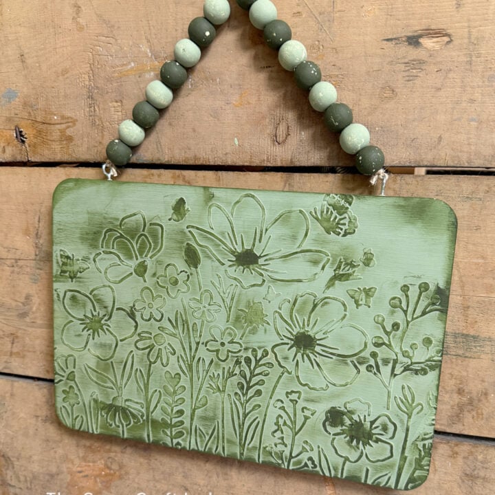 green textured floral sign with wood bead hanger