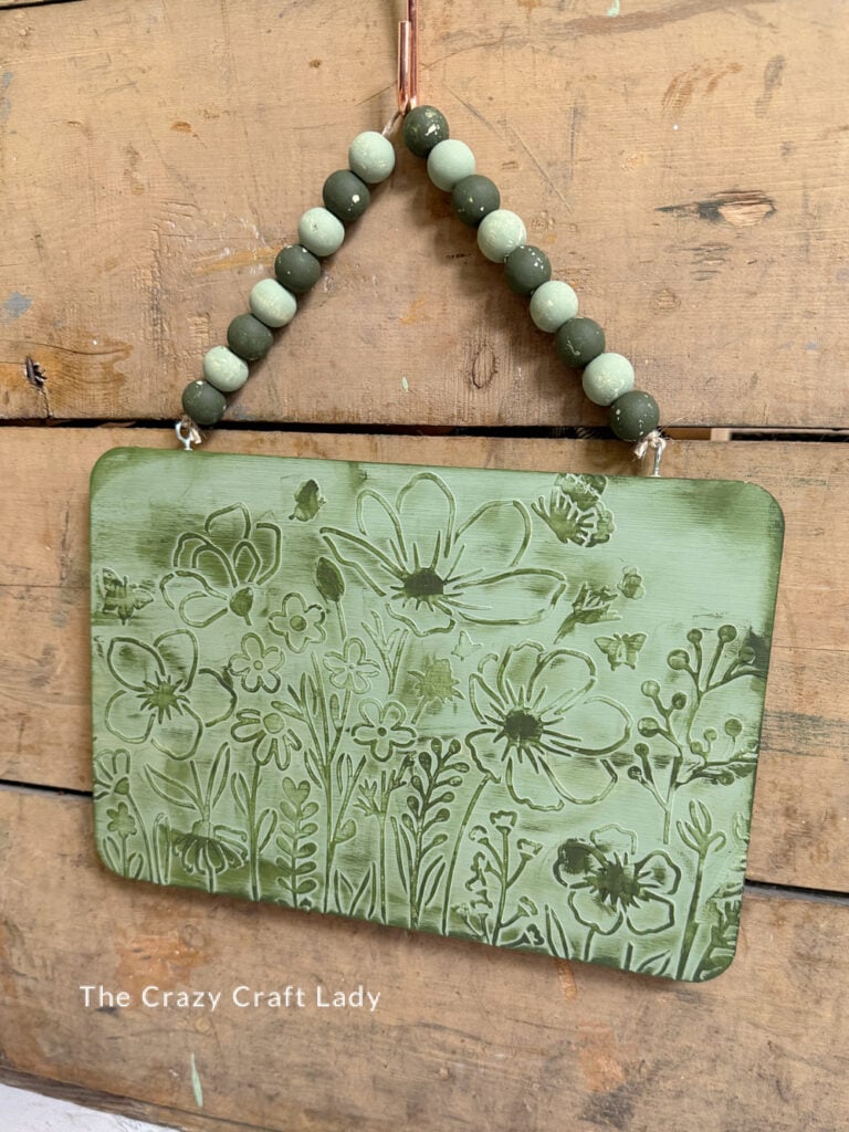 green textured floral sign with wood bead hanger