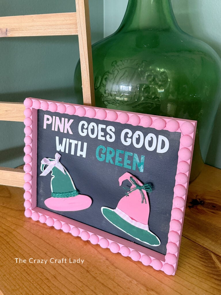Pink Goes Good with Green sign with a bobbin edge frame