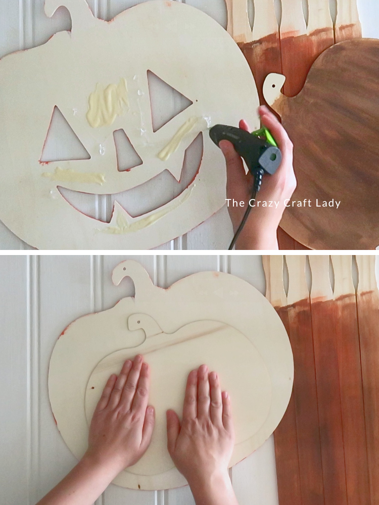 hot glue the brown wood backer behind the jack-o-lantern face