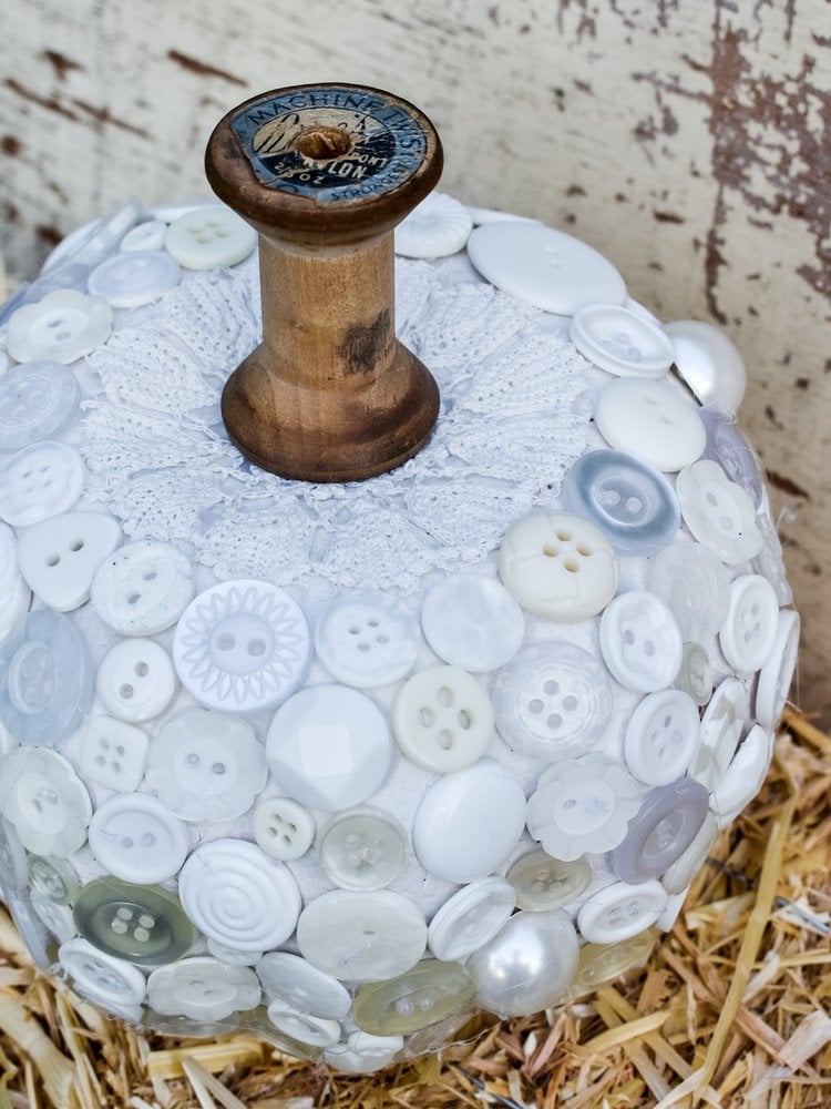 Button covered Dollar Tree foam pumpkin with thread spool stem
