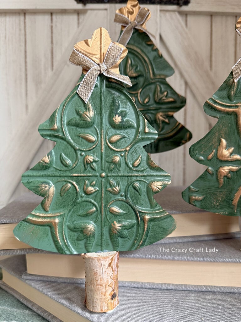 Three dollar store tin tile Christmas trees with birch log bases and burlap bows